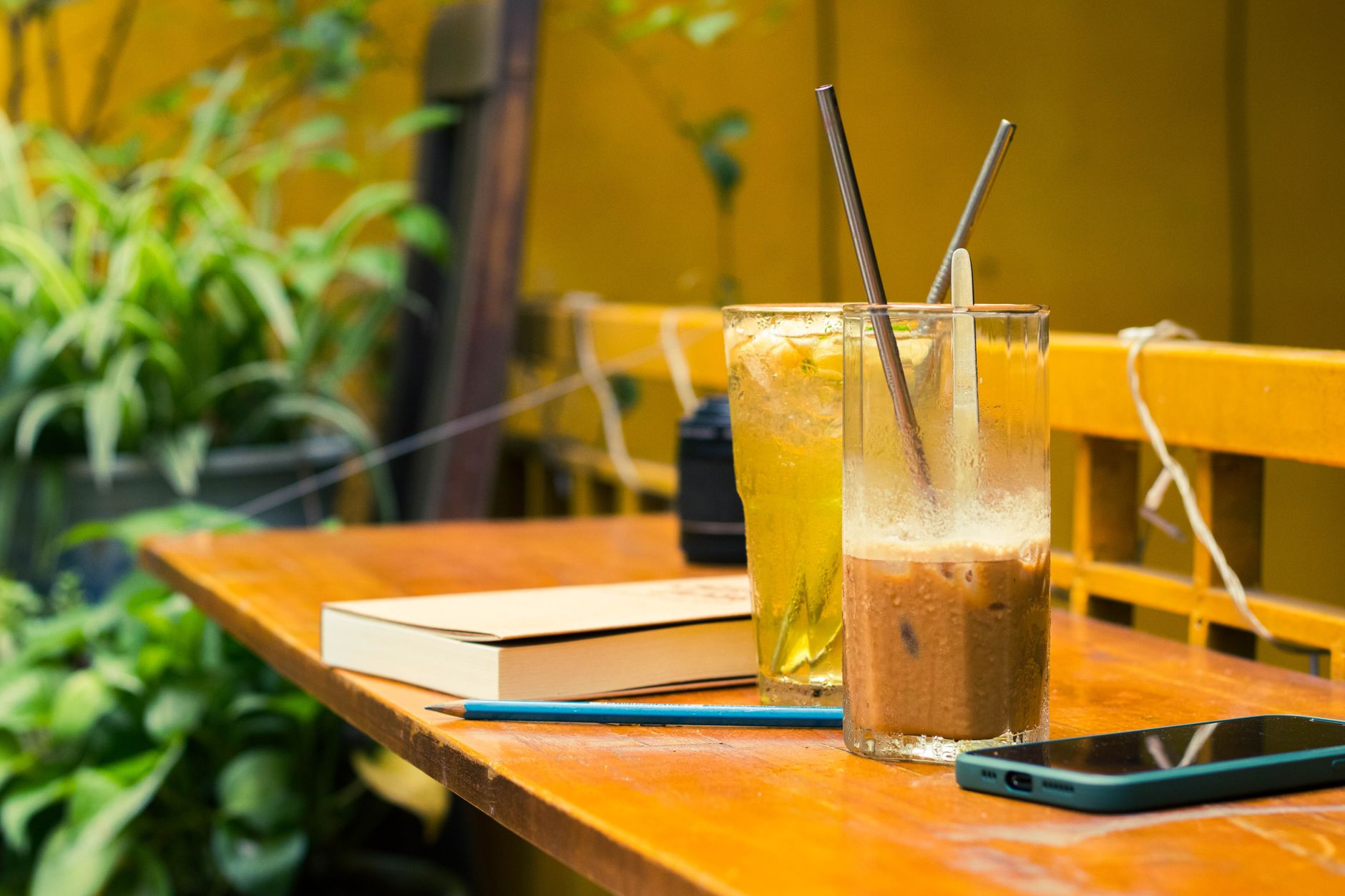 cozy outdoor cafe table with refreshing drinks and book